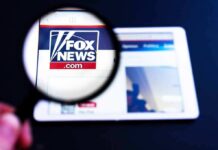Outrage Erupts: Fox Star Shreds DHS Boss Magnifying glass over Fox News website logo on a tablet