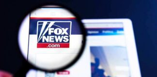 Magnifying glass over Fox News website logo on a tablet