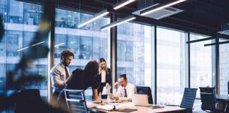 Business team collaborating at a conference table in a modern glass-walled office