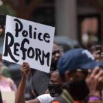 Protester holding a sign at a crowded demonstration
