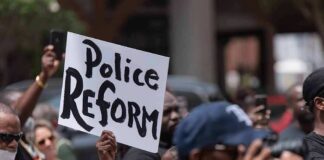 Protester holding a sign at a crowded demonstration