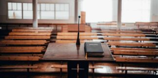 Podium with microphone and book in empty lecture hall