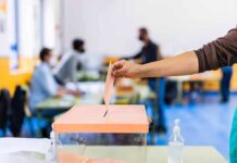 Hand casting ballot into a box at a polling station