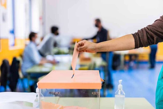 Hand casting ballot into a box at a polling station