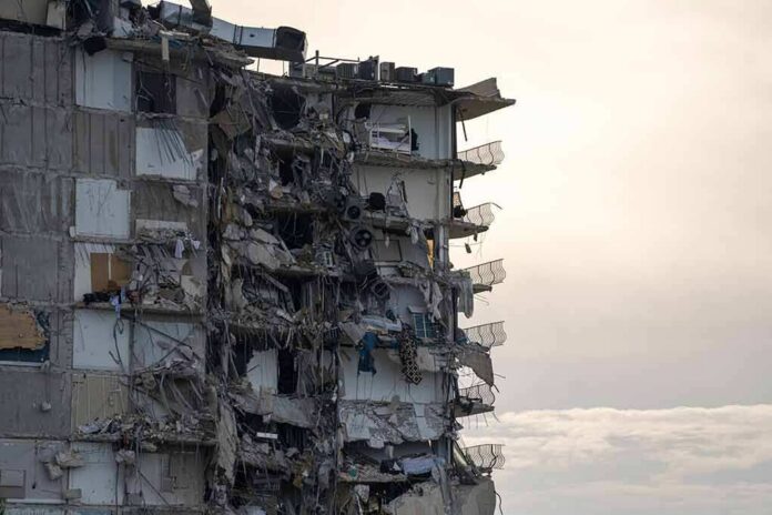 Partially collapsed apartment building with exposed rooms and debris