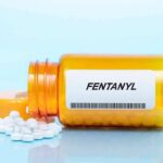 Orange pill bottle labeled Fentanyl with white tablets spilled out
