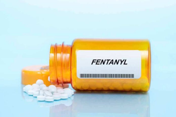 shutterstock_2174954171 Orange pill bottle labeled Fentanyl with white tablets spilled out