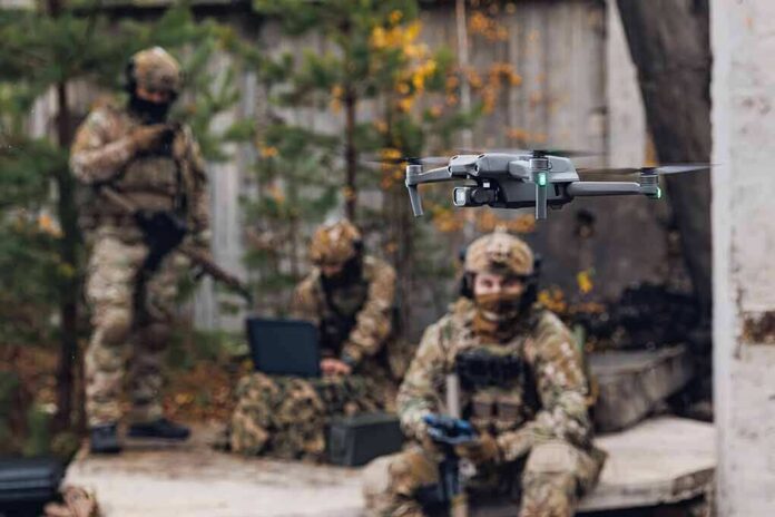 Quadcopter drone flying near camouflaged soldiers outdoors