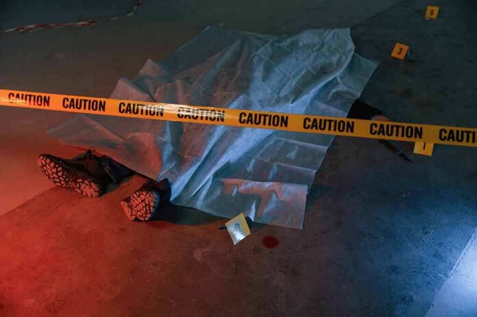 shutterstock_2245205881 crime scene body under sheet behind caution tape