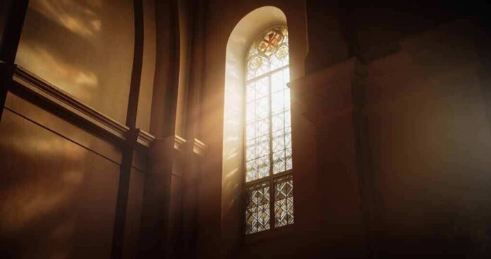 shutterstock_2253550973 sunlit stained glass window in a church interior