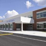 Modern school building with large windows and a clear sky