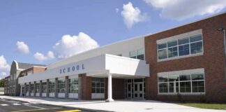 Modern school building with large windows and a clear sky