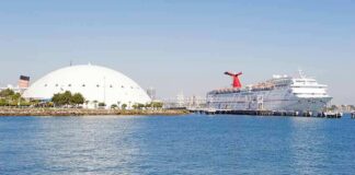 Cruise ship docked beside a large white domed building