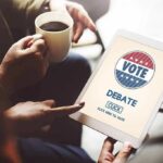Hands holding a tablet with a voting screen and a person holding coffee