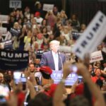Ballot Bombshell: Trump Demands Center Stage man at podium addressing a large crowd at a rally
