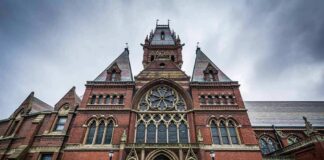Gothic Revival brick building with ornate arched entrance and large rose window