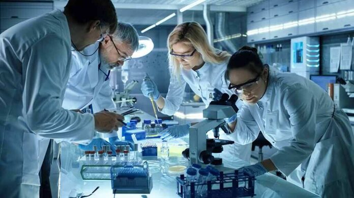 Scientists collaborating in a laboratory around a microscope