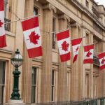 Canadian flags on a neoclassical building facade