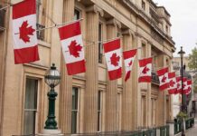 Base Inferno Sparks RCMP Probe Canadian flags on a neoclassical building facade
