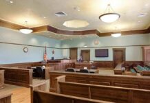 Aurora Temple Targeted – Disturbing Trail Emerges Empty courtroom with wooden benches and judge's bench