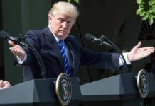 Donald Trump speaking at dual podiums with arms outstretched