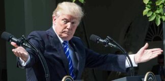 Donald Trump speaking at dual podiums with arms outstretched