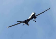 military drone flying in a clear blue sky