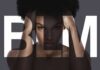 Woman with afro framed by large letters