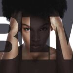 Woman with afro framed by large letters