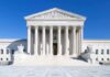 Blackout Emails: Musk – Abbott Mystery Deepens The Supreme Court building featuring marble columns and a clear blue sky