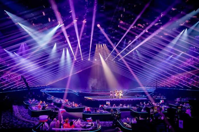Concert stage with performers under purple laser lights