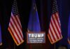 Trump Turns Up Heat In Georgia Podium with campaign sign between American flags