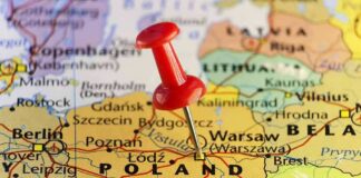 Red pushpin marking Poland on a European map
