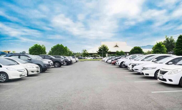 shutterstock_797260003-2 Parking lot lined with cars under a blue sky